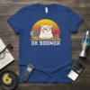 OK BOOMER cat t-shirt with a white cat wearing glasses and a retro sunset graphic