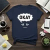 Navy blue t-shirt with "OKAY" in a speech bubble above a tired, unimpressed face graphic