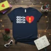 Navy t-shirt with white text "Olivia Olivia Olivia!" next to a red heart with a yellow exclamation mark