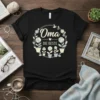 Black t-shirt with "Oma Die Beste" in German, surrounded by a floral wreath and potted flowers