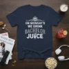 Navy blue t-shirt with white text "On Monday's We Drink Bachelor Juice" and a cocktail glass graphic