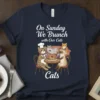 Navy t-shirt featuring the text "On Sunday We Brunch with Our Cats Cats" and a graphic of cats enjoying brunch