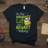 Dark t-shirt with "On The Naughty List And I Regret Nothing" text and a Grinch-like cat wearing a Santa hat