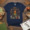 Navy t-shirt with "ONE THANKFUL TEACHER" text and a fall tree graphic with pumpkins and hearts