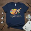 Oops! I Arted. text with a colorful art palette and paintbrush graphic on a navy t-shirt