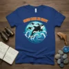Orcas Make Me Happy text above a graphic of orcas jumping in ocean waves, on a royal blue t-shirt