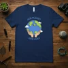 Our Planet Our Lives t-shirt design with hands holding the Earth, clouds, and birds. Features blue and green colors, conveying