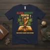 Black History Month t-shirt with "Our Roots Shape Our Future" slogan, featuring images of Martin, Maya, Harriet, and Garvey