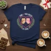 Owl You Need Is Love t-shirt with two cartoon owls sitting on a branch inside a heart, surrounded by leaves