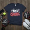 Dark navy t-shirt with "PADEL Queen" text in white and red, featuring a crown and a padel racquet graphic
