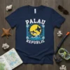 Navy blue t-shirt with "Palau Republic" text, shark, manta ray, ocean waves, and sun graphic