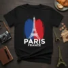 Black t-shirt with white PARIS FRANCE text and Eiffel Tower graphic, set against red and blue brush strokes