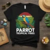 Parrot Tropical Vibes t-shirt design featuring a blue and yellow macaw on a branch with tropical leaves and a sunset