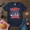Navy blue t-shirt with "PARTY in the USA" text, American flag graphic, and eagle illustration, perfect for Fourth of July