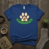 Paw print graphic with a house inside, set on a green banner, on a blue t-shirt. Paw House Design