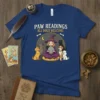 Paw Readings All Dogs Welcome text with witch and dogs graphic on a blue t-shirt