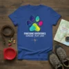 Pawsome Adventures Explore Play Love t-shirt with a colorful geometric paw print and compass graphic