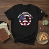 Black t-shirt with white text PEACE AMERICA UNITY encircling a peace symbol filled with the American flag design