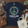 Navy t-shirt with white text "PEACE & LOVE EST. 1960s" below a floral peace symbol graphic