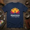 Peacock Sunset Symphony text design with a colorful peacock illustration on a navy t-shirt