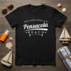 Black t-shirt featuring white text "Pensacola Beach Florida Established 18 21" with palm trees and star graphics