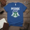 Pferde Junge T-Shirt with graphic of a young boy in equestrian gear between two horses, mountains, and trees