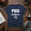 Navy blue t-shirt with white text "PHD in BIKEOLOGY" and a bicycle gear with an open book graphic