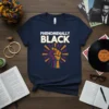 Navy t-shirt with white text "Phenomenally Black" above a graphic of a raised fist with colorful rays