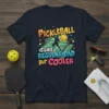 Pickleball is like regular dad but cooler text and graphic of a pickleball player on a t-shirt