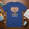 PICU Nurse T-Shirt with a heart-shaped tree design showing children and colorful leaves. Features the text "PICU nurse" below