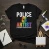 Police Artist T-Shirt with a rainbow pride badge and artistic elements. Features text "POLICE" and "ARTIST"