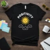 Black t-shirt with white "POSITIVITY" text, a yellow smiling sun graphic, and three white smiling cloud graphics