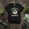 Powered By Plants T-Shirt featuring a muscular arm surrounded by fresh vegetables and the words "Powered By Plants"