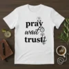 White t-shirt with black text "pray wait trust" and religious symbols including praying hands, stopwatch, tree, and anchor