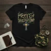 Black t-shirt with "PRAYER WARRIOR" in camouflage font and a shining cross graphic below