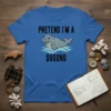 Blue t-shirt with "Pretend I'm a Dugong" text and a cartoon dugong swimming in waves