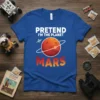 Pretend I'm The Planet Mars text with a graphic of Mars and a spaceship on a blue t-shirt