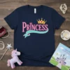 Navy blue t-shirt with "Princess" text in pink glitter font and a golden crown graphic above