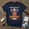 Promoted to Daddy 2021 t-shirt featuring a muscular shark in a jersey and a baby stroller graphic