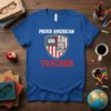 Proud American Teacher text and shield graphic with books and US flag elements on a blue t-shirt