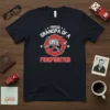 Proud Grandpa Of A Firefighter T-Shirt featuring a firefighter emblem with a helmet and axe, text in white and red