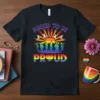Proud to be Proud text with rainbow sun, silhouetted people jumping, and rainbow heart graphic on a black t-shirt