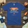 Puerto Banús Andalucía text with sunset harbor graphic and coordinates on a blue t-shirt