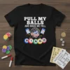 Black t-shirt with white text "PULL MY BALLS AND MAKE ME YELL" above a bingo cage graphic with balls and