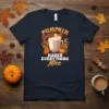 Pumpkin Spice Makes Everything Nice text with a mug of coffee, pumpkins, and autumn leaves graphic on a navy t-shirt