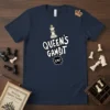 Queen's Gambit C4! text and chess queen graphic on a navy blue t-shirt, with chess pieces scattered around