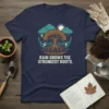 T-shirt design with the quote "Rain Grows The Strongest Roots" above a graphic of a tree with strong roots during