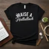 Black t-shirt with white text "RAISE A Hallelallach" and stylized hands with stars graphic