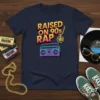 Raised on 90's Rap t-shirt with retro boombox graphic and gold chain pendant, navy blue color