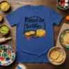Raised on Tortillas t-shirt design with black script text and illustration of tortillas on a comal